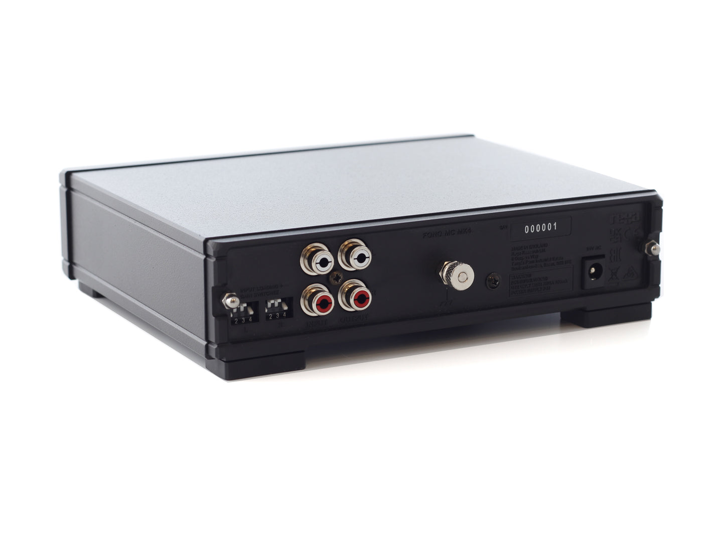 Product image of the rear panel of a Rega Fono MC Phono Stage showing the RCA input and output as well as the power input, dip switches and grounding pin.