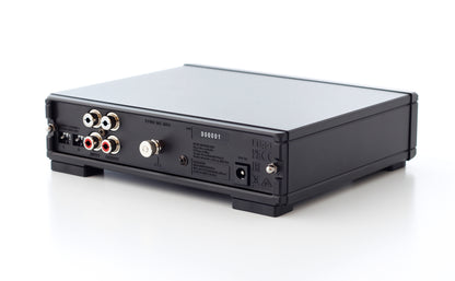 Product image of the rear panel of a Rega Fono MC Phono Stage showing the RCA input and output as well as the power input, dip switches and grounding pin.