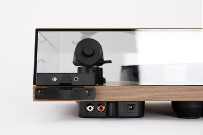 Product image for the rear of a Rega Planar 1 Plus turntable in Walnut finish showing the RCA output sockets and power socket
